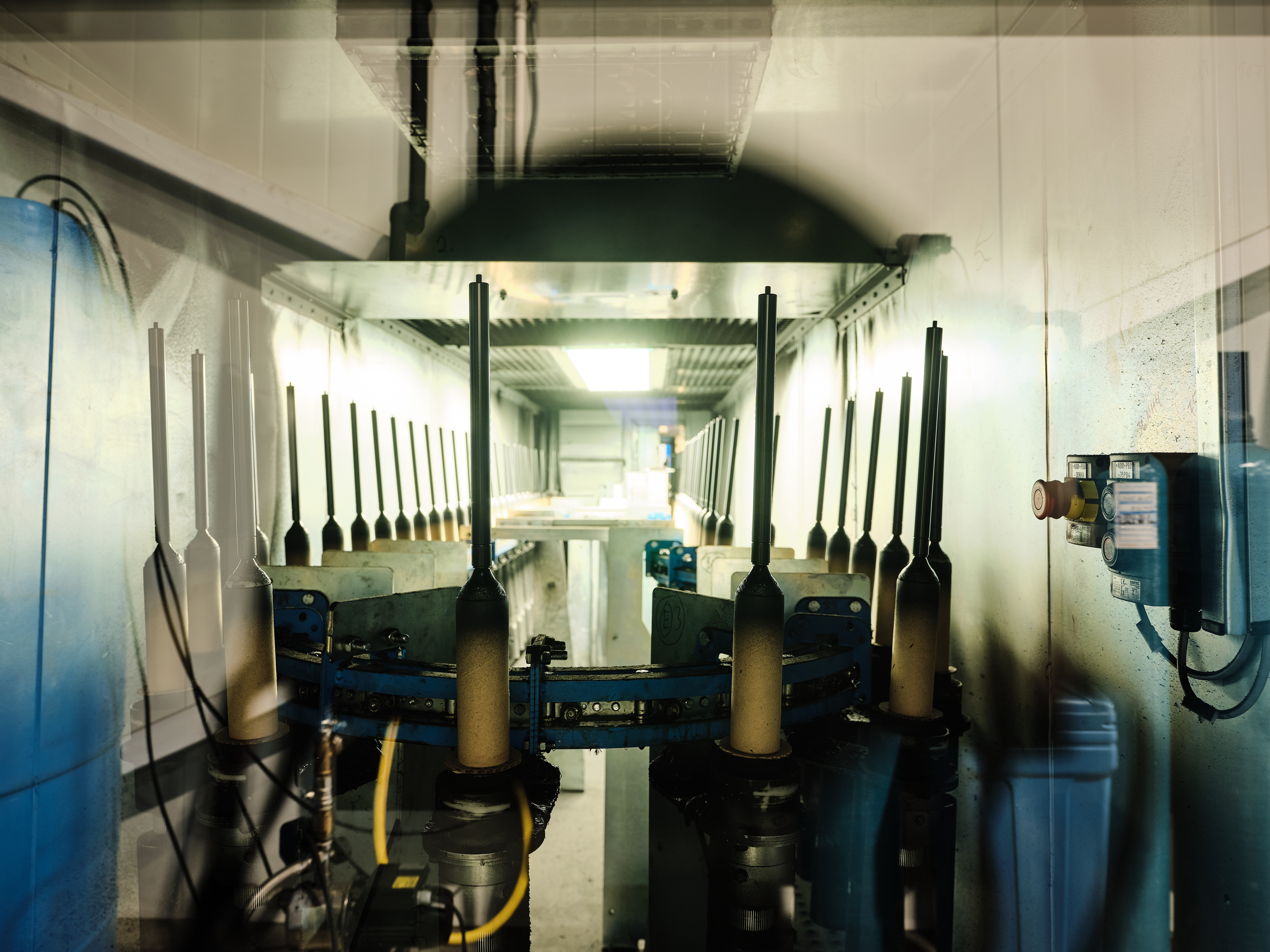 A dimly lit hallway with industrial machinery, metal components, and pipes.