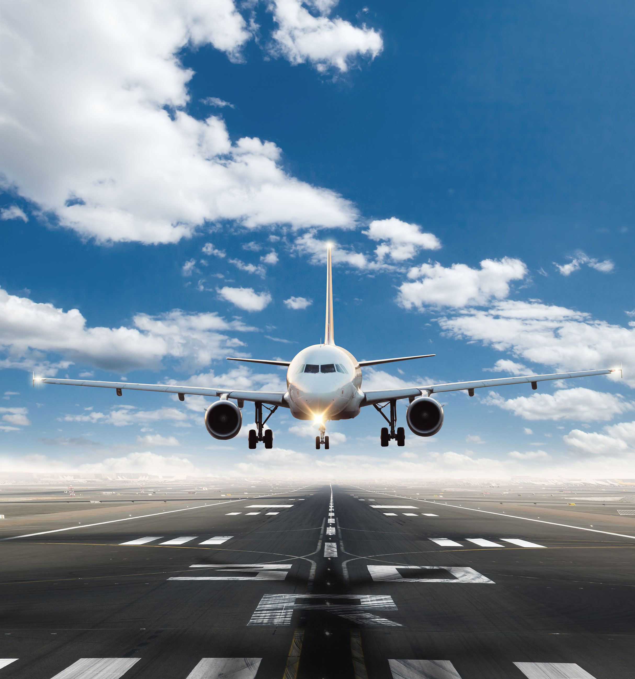 A passenger aircraft landing on a runway against a blue sky, representing real-world aerospace applications for Lesjöfors springs and components.