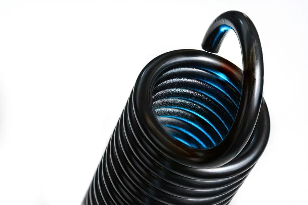 A macro close-up of a black tension spring end loop.