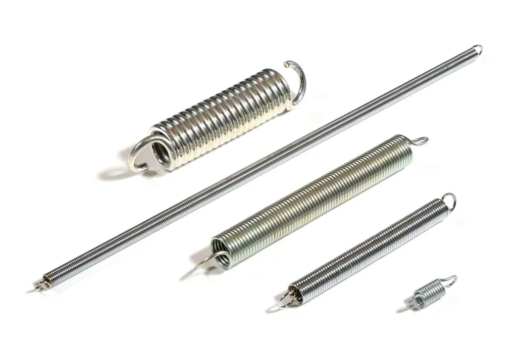 Four tension springs of various sizes on a white background.