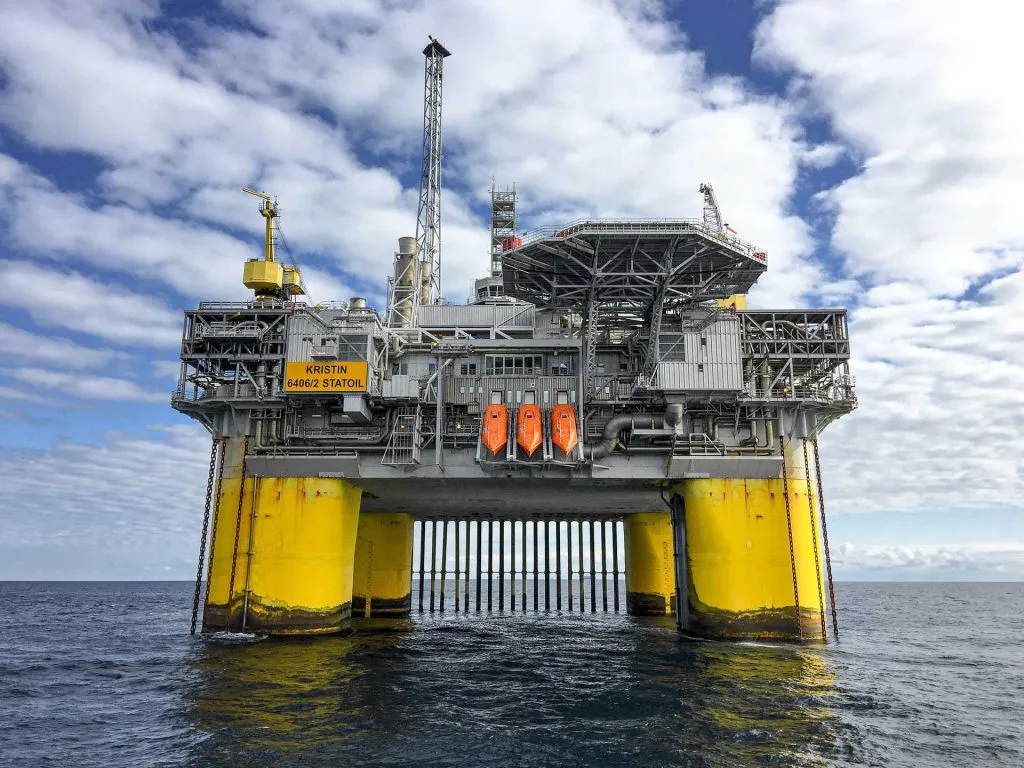 Large offshore oil and gas platform supported by subsea structure in open ocean under daylight sky