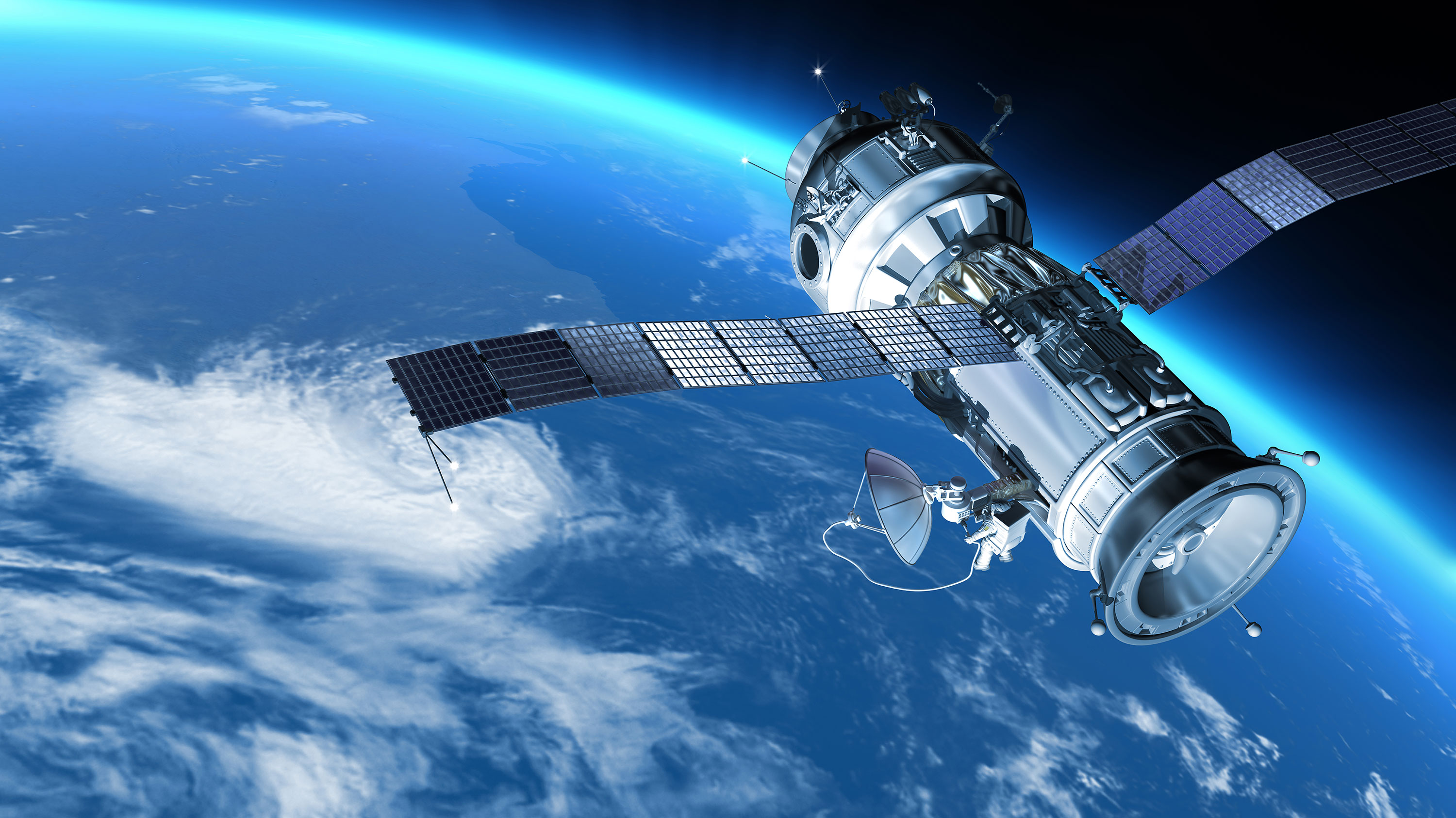 A satellite with large solar panels orbits Earth. Below, white clouds and vibrant blue oceans are visible.