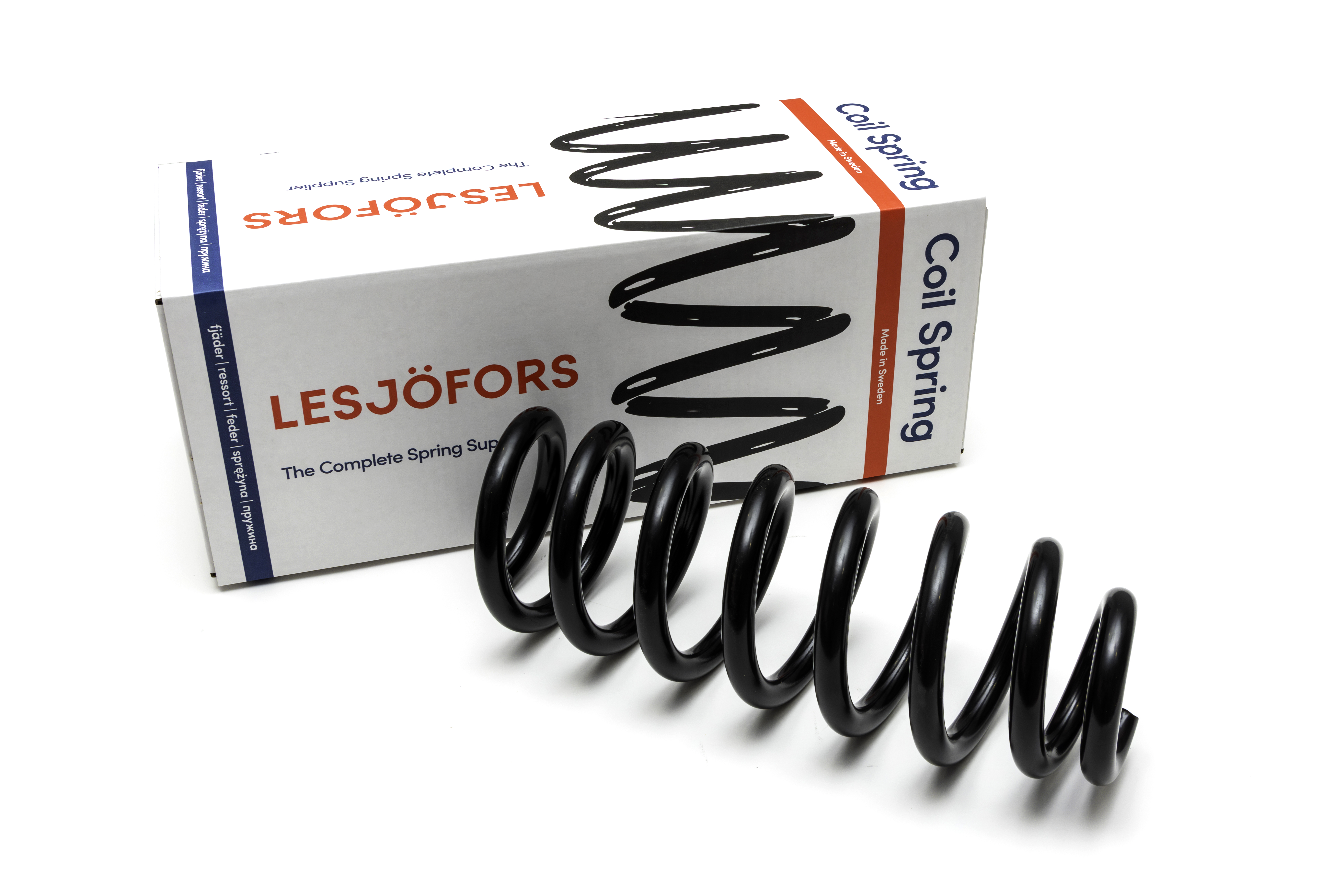 A black chassis spring is displayed in front of a branded Lesjöfors box, suggesting automotive or mechanical use.