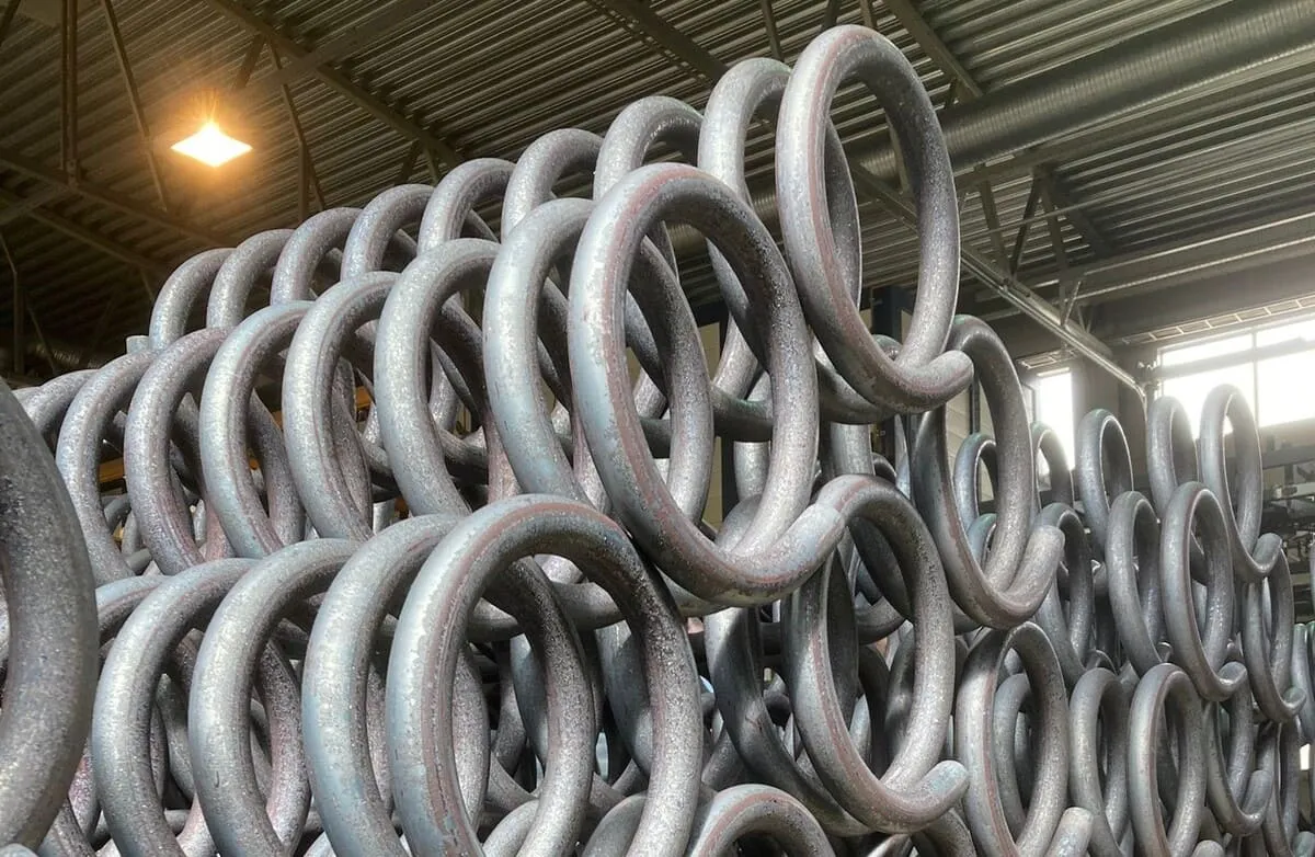 Stacked steel coil springs inside a Lesjöfors manufacturing facility.