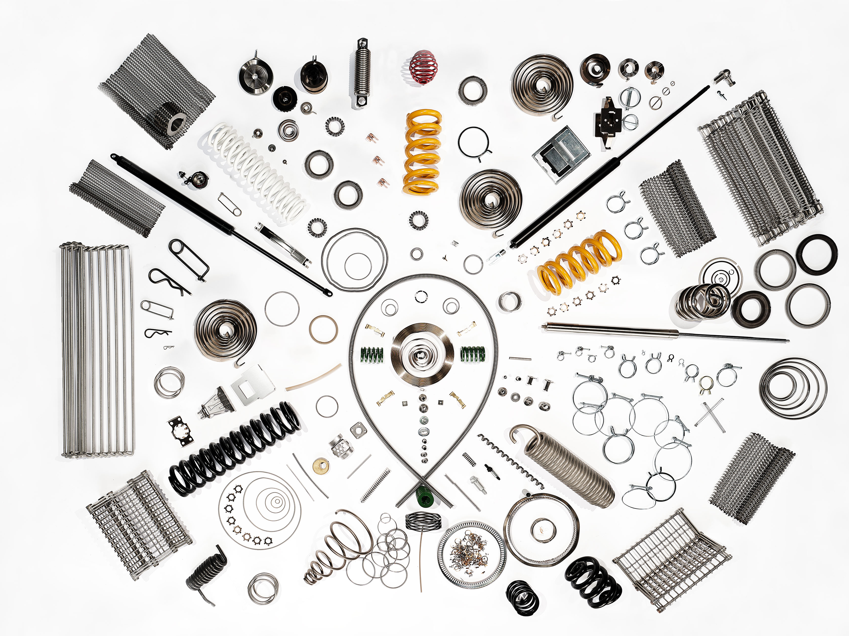 A geometric arrangement of industrial metal springs and precision components on a white background, showcasing different shapes, sizes, and coil structures and highlighting engineering design and manufacturing quality.