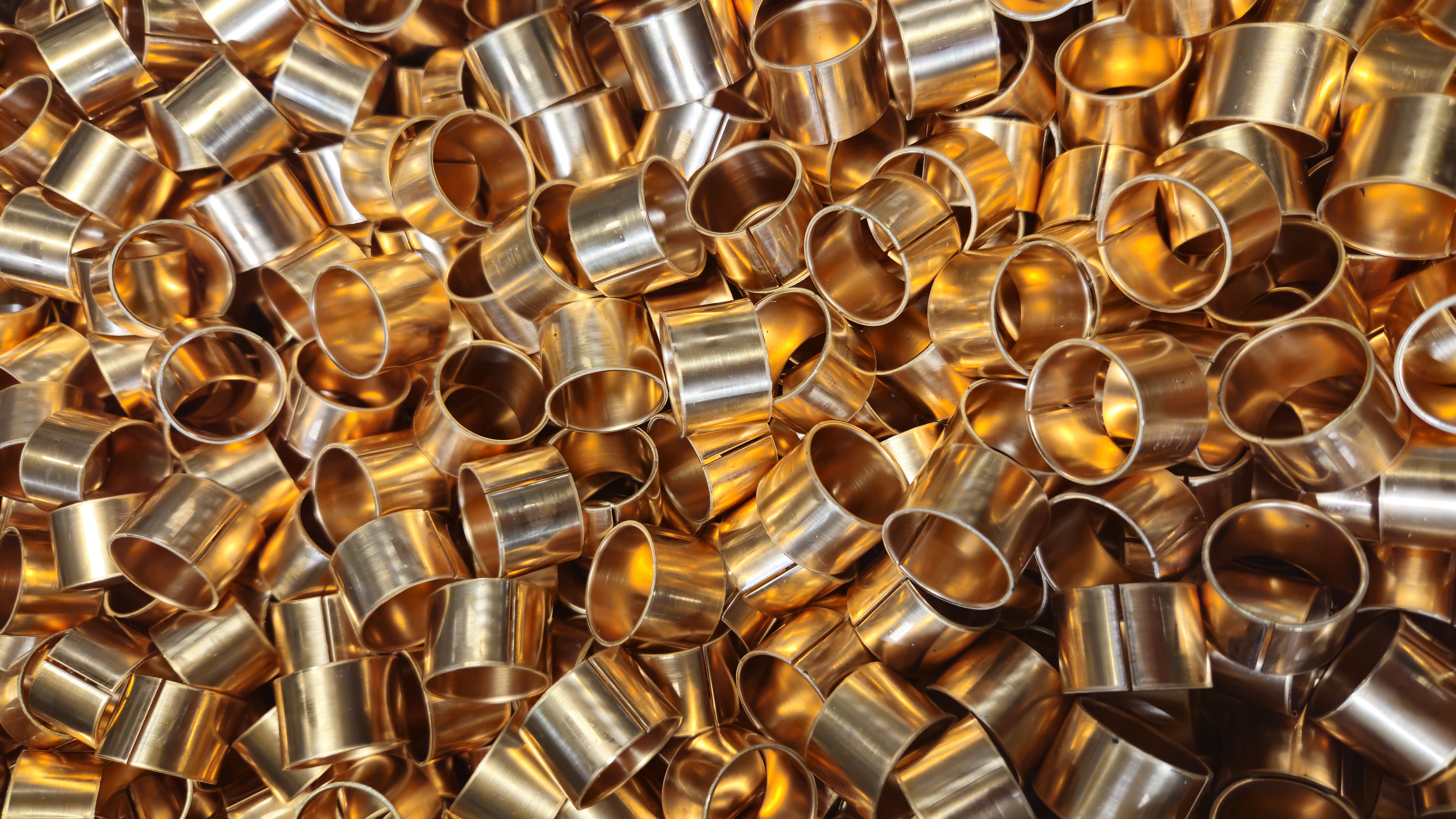 Close-up of precision-manufactured bronze bushings ready for industrial applications.
