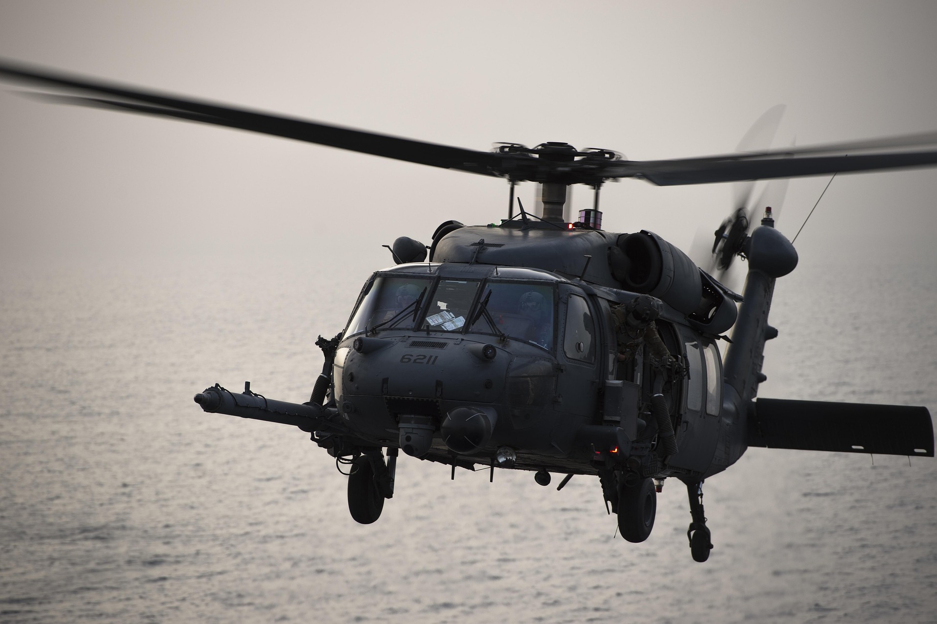 Military helicopter flying over the sea.