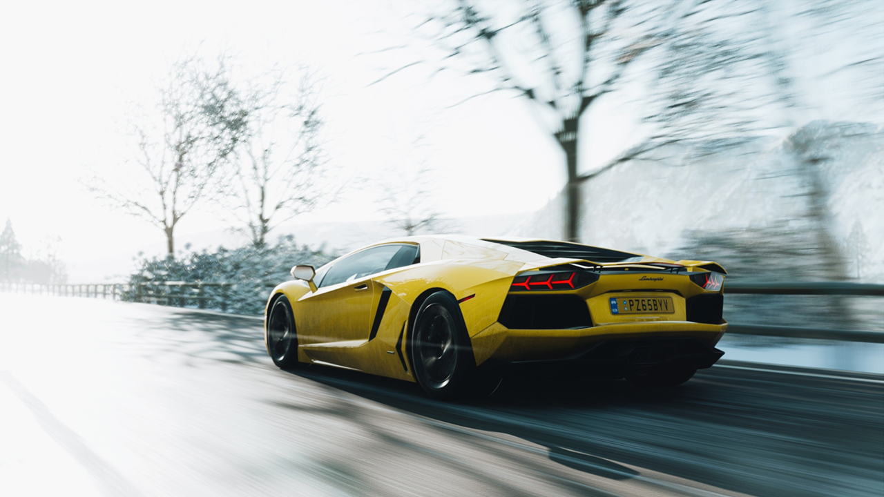 A yellow sports car driving on a road at high speed.