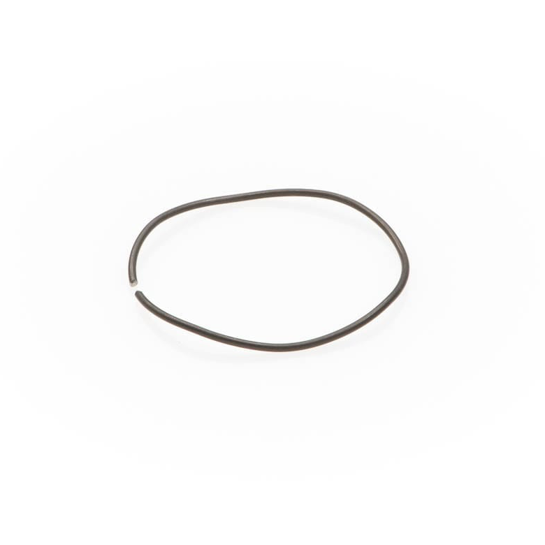 A thin metal wave spring formed in an uneven circular shape with a small opening on a white background.