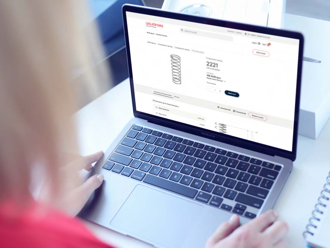 Woman using a laptop to view a compression spring on the Lesjöfors webshop.